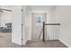 Bright hallway featuring carpet floors, a window, and an open doorway to a living area with a comfortable sofa at 2008 Campana Dr, Raleigh, NC 27603