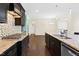 Gourmet kitchen with stainless steel appliances, granite countertops, dark cabinets, and a view into the dining area at 2008 Campana Dr, Raleigh, NC 27603