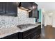 This kitchen features stainless steel appliances, granite counters, mosaic tile backsplash, and dark cabinetry at 2008 Campana Dr, Raleigh, NC 27603