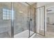 Glass enclosed shower with tile surround, shower head and shelves in a bathroom at 2008 Campana Dr, Raleigh, NC 27603