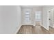 Bright foyer with wood-look flooring, white trim, and glass panel front door at 206 Jetson Creek Way, Youngsville, NC 27596