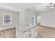 Kitchen island with granite countertops and white cabinets, and sliding glass door to backyard at 206 Jetson Creek Way, Youngsville, NC 27596