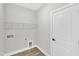 Unfinished laundry room with utility connections, shelving and a white door at 206 Jetson Creek Way, Youngsville, NC 27596