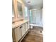 A bathroom featuring a double sink vanity and shower with glass doors at 209 King St, Oxford, NC 27565