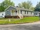 Charming one-story home featuring gray siding and a welcoming front porch at 209 King St, Oxford, NC 27565