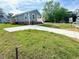 Corner view of the home featuring vinyl siding, replacement windows, and a new driveway at 209 King St, Oxford, NC 27565