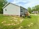 View of the back of the house with a wooden deck and green siding at 209 King St, Oxford, NC 27565