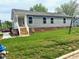 Exterior of single story home with gray siding and brick foundation at 209 King St, Oxford, NC 27565