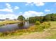 Scenic pond view with lush green surroundings, reflecting the surrounding homes and trees under a bright, blue sky at 228 N Maple Walk Dr # 228, Garner, NC 27529