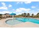 Inviting community pool area featuring a splash fountain, lounge chairs, and a clubhouse under a sunny, blue sky at 228 N Maple Walk Dr # 228, Garner, NC 27529