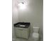 Bathroom with a white toilet and cabinet with dark countertops and walls painted light gray at 2590 Silas Peak Ln, Apex, NC 27523