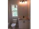 Bathroom featuring a toilet, a white cabinet with a sink and a window with natural light at 2590 Silas Peak Ln, Apex, NC 27523