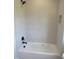 Bathroom with a white bathtub and gray patterned tile on the walls and a black shower head at 2590 Silas Peak Ln, Apex, NC 27523