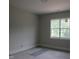 A cozy bedroom features a bright window with views of the trees outside at 2590 Silas Peak Ln, Apex, NC 27523