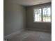 Well-lit room with light-colored walls, white trim, and a large window overlooking the yard at 2590 Silas Peak Ln, Apex, NC 27523
