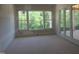 An unfinished bedroom with large windows offering serene nature views and access to a private balcony at 2590 Silas Peak Ln, Apex, NC 27523