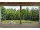 Covered deck with a metal railing and a picturesque view of the green forest at 2590 Silas Peak Ln, Apex, NC 27523