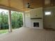 Covered deck with a cozy fireplace and scenic views of the surrounding trees at 2590 Silas Peak Ln, Apex, NC 27523