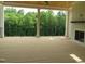 Spacious covered deck featuring wood floors, a fireplace, and views of lush trees at 2590 Silas Peak Ln, Apex, NC 27523