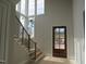 Bright entryway with modern stairs, wooden front door, and tall windows that flood the space with natural light at 2590 Silas Peak Ln, Apex, NC 27523