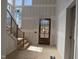 Light-filled entry featuring wood door, staircase with black railings, and large windows at 2590 Silas Peak Ln, Apex, NC 27523
