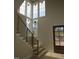 Light-filled entryway with views and a modern staircase with stylish railing and a wooden glass paneled front door at 2590 Silas Peak Ln, Apex, NC 27523