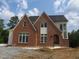New two story brick home with white trim and black roof in a partially landscaped lot at 2590 Silas Peak Ln, Apex, NC 27523