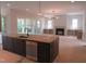 Spacious kitchen with a dark island, stainless steel appliances, and an open layout at 2590 Silas Peak Ln, Apex, NC 27523