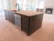 Kitchen with a dark island, stainless steel appliances, and open access to the living room at 2590 Silas Peak Ln, Apex, NC 27523