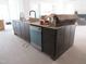 Spacious kitchen island with dark wood cabinets, a sink, and stainless steel dishwasher at 2590 Silas Peak Ln, Apex, NC 27523