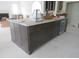 Large kitchen island with dark wood cabinets offering ample storage, as well as a stainless dishwasher at 2590 Silas Peak Ln, Apex, NC 27523