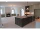 Modern kitchen featuring a dark kitchen island and stainless steel appliances at 2590 Silas Peak Ln, Apex, NC 27523