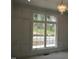 White paneled living room wall with window overlooking construction site and wooded area at 2590 Silas Peak Ln, Apex, NC 27523
