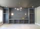 Custom built-in shelving and a unique light fixture accent the room with large windows at 2590 Silas Peak Ln, Apex, NC 27523