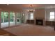 Open-concept living area with fireplace, modern light fixture, and access to the patio at 2590 Silas Peak Ln, Apex, NC 27523