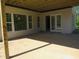 Outdoor patio with windows and French doors overlooks a private backyard setting at 2590 Silas Peak Ln, Apex, NC 27523