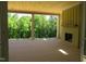 Covered porch featuring wood flooring, an outdoor fireplace, and views of the surrounding trees at 2590 Silas Peak Ln, Apex, NC 27523