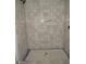 Modern shower featuring beige tile with a contrasting showerhead at 2590 Silas Peak Ln, Apex, NC 27523