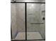 Modern stand up shower with glass door and dark hardware and white tile walls at 2590 Silas Peak Ln, Apex, NC 27523