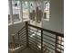 Modern staircase with chandelier and multi-pane windows, enhancing the space with light and style at 2590 Silas Peak Ln, Apex, NC 27523