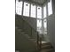 Modern staircase with oak and black metal railing next to large window array at 2590 Silas Peak Ln, Apex, NC 27523