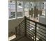 Bright staircase with oak railing and black metal balusters next to large windows at 2590 Silas Peak Ln, Apex, NC 27523