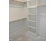 Bright walk-in closet with shelving, wooden rod, and white walls offers plenty of storage space at 2590 Silas Peak Ln, Apex, NC 27523