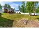 Lush backyard with a wooden deck, surrounded by trees and offering ample space for outdoor activities at 27 Ashley Woods Ct, Clayton, NC 27527
