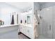 Bright bathroom featuring double vanity, modern lighting, walk-in shower with glass door, and decorative bath mat at 27 Ashley Woods Ct, Clayton, NC 27527