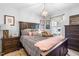 Cozy bedroom featuring a queen-sized bed with a dark wood frame, neutral bedding and decor at 27 Ashley Woods Ct, Clayton, NC 27527