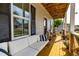 Charming covered front porch with a cozy couch, modern decor, and beautiful flowers at 27 Ashley Woods Ct, Clayton, NC 27527
