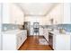 Modern kitchen with stainless steel appliances, white cabinets, and subway tile backsplash at 27 Ashley Woods Ct, Clayton, NC 27527