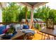 Relaxing porch with comfortable seating, wooden tables, and a peaceful view of the lush green trees at 27 Ashley Woods Ct, Clayton, NC 27527