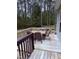 Deck featuring an outdoor dining area with table and chairs, overlooking the wooded backyard at 282 W Thicket Dr, Angier, NC 27501
